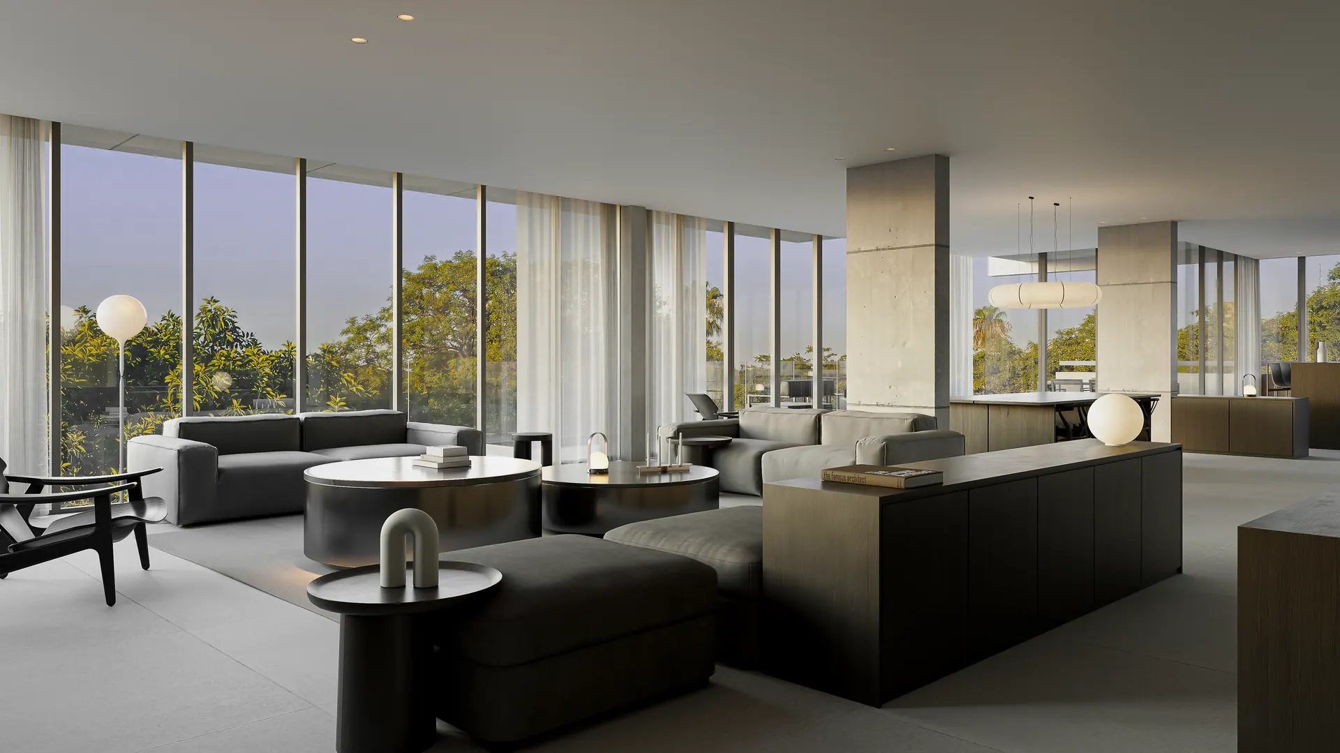 Living de una residencia con ventanales de piso a techo y vista a los árboles